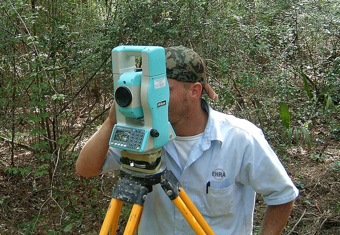 A land surveyor from EHRA Engineering: Land Surveying using survey equipment out in the field. Фото: Random…