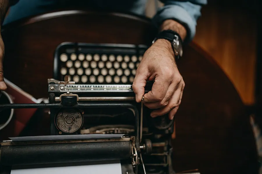 A man adjusting an old typewriter closeup.. Фото: Shixart1985 / CC BY 2.0, via Wikimedia Commons