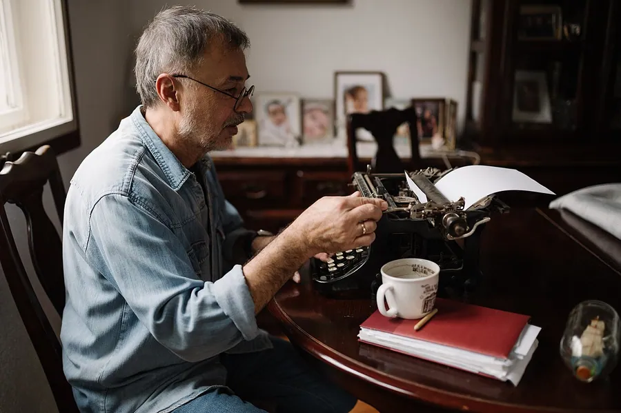 Middle-aged man working on an old typewriter at home.. Фото: Shixart1985 / CC BY 2.0, via Wikimedia Commons