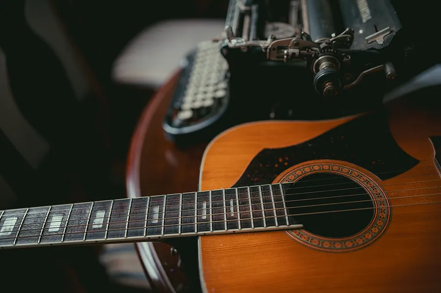 Accoustic guitar and an old typewriter at home closeup.. Фото: Shixart1985 / CC BY 2.0, via Wikimedia Commons
